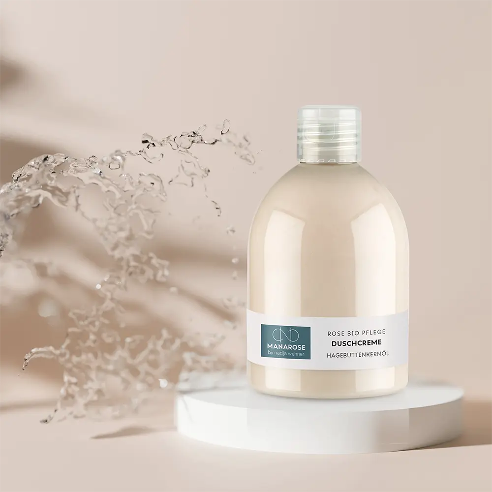 Eine Flasche Manarose Biokosmetik Körperlotion mit einem Spritzer Wasser, angereichert mit Duschcreme Hagebuttenkernöl und Hagebuttenkernöl.