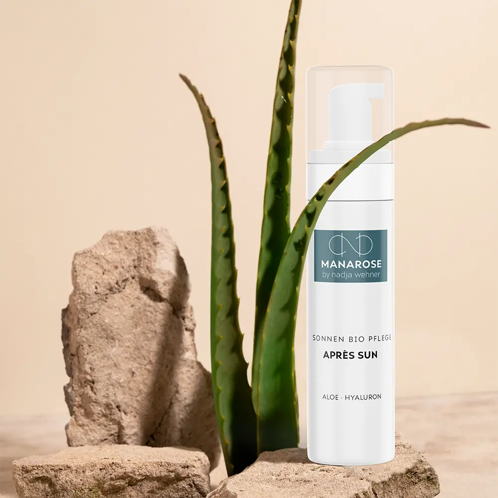 Eine Flasche Après Sun Aloe Hyaluron von Manarose Biokosmetik sitzt auf einem Felsen.