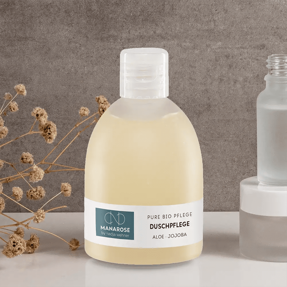 Eine Flasche Duschpflege Aloe Jojoba Gesichtsreiniger neben einer Flasche Wasser für Manarose Biokosmetik und Haut.