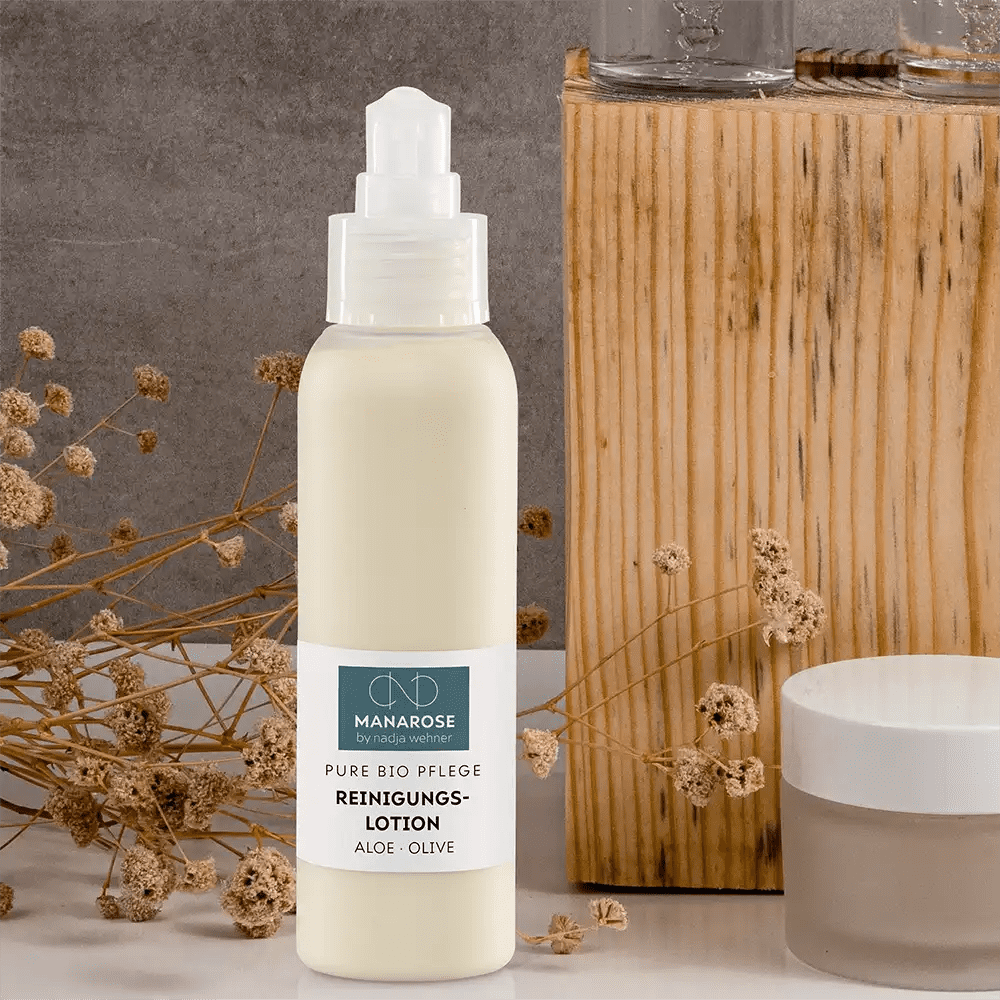 Eine Flasche Manarose Biokosmetik Reinigungslotion Aloe Olive Körperlotion neben einer Holzkiste.