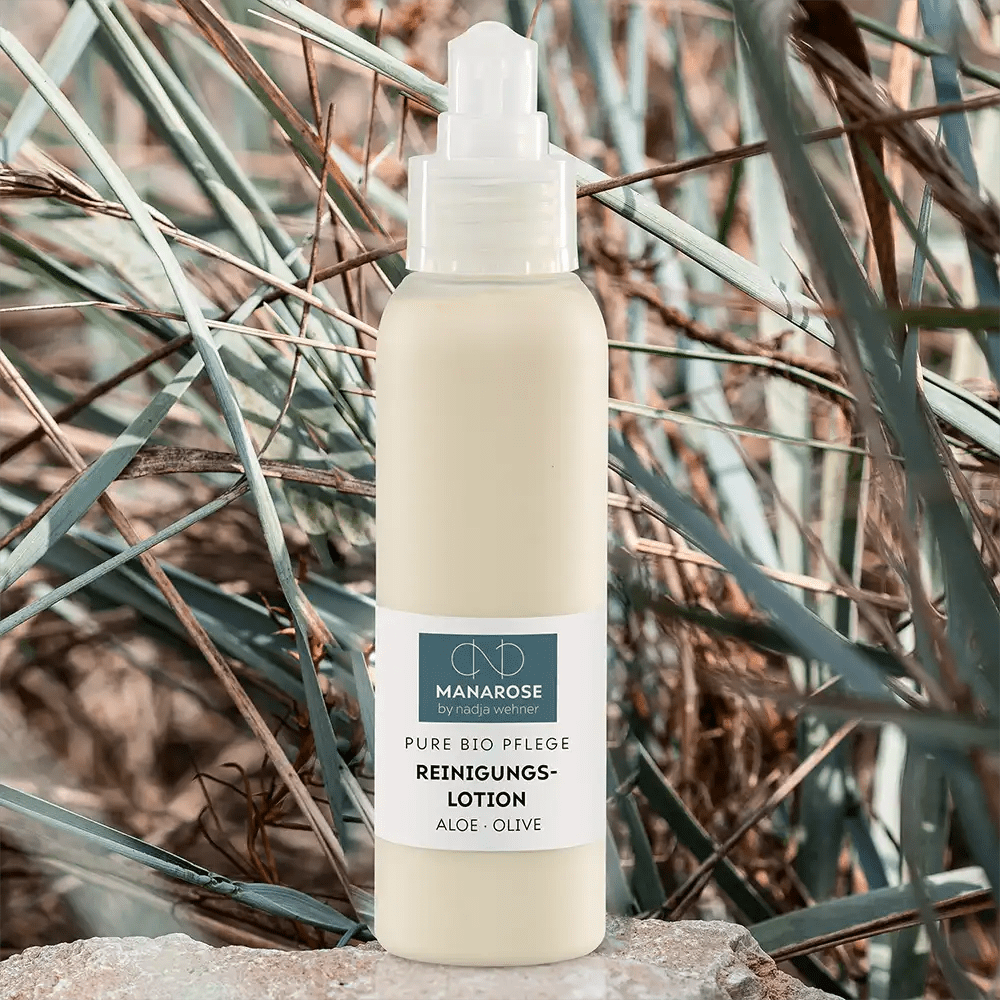 Eine Flasche Reinigungslotion Aloe Olive mit Manarose Biokosmetik auf einem Felsen.