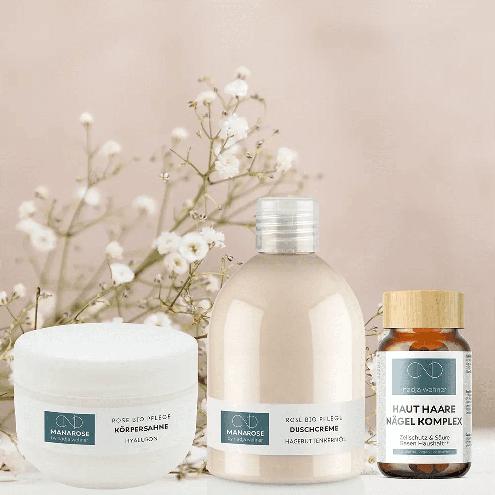 Eine Flasche Manarose Biokosmetik Pflegeset - Perfect Legs Hautpflegeprodukt neben Blumen auf weißem Hintergrund.