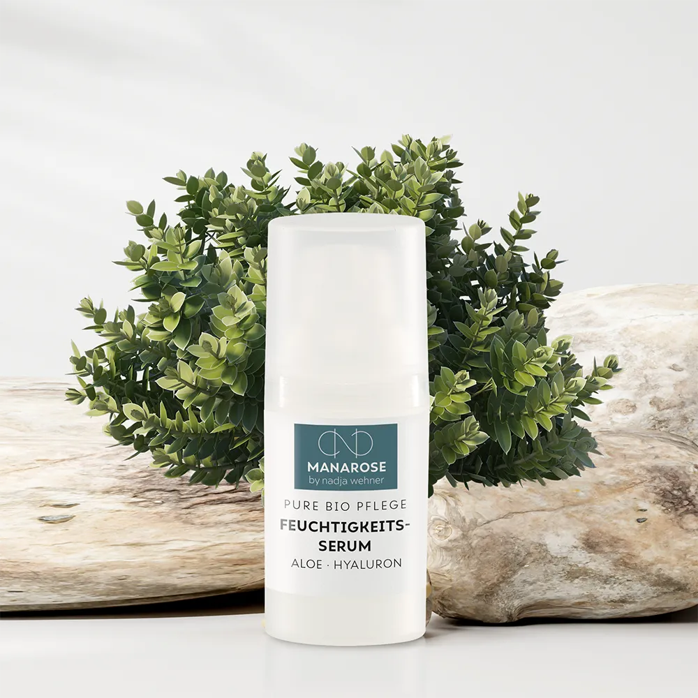Eine Flasche Feuchtigkeits-Serum Aloe Hyaluron von Manarose Biokosmetik auf einem Tisch neben einer Pflanze, die der Haut Feuchtigkeit und Nährstoffe spendet.
