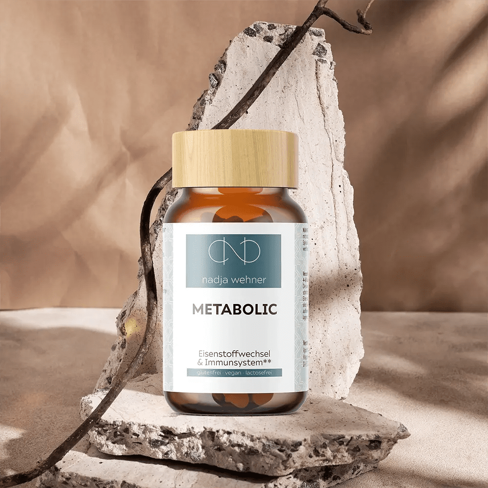 Eine Flasche Metabolic Care Spirulina sitzt auf einem Felsen. Markenname: Manarose Biokosmetik.