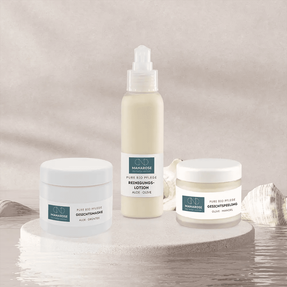 Ein Set von Manarose Biokosmetik-Hautpflegeprodukten, darunter das Gesichtsreinigungsset - Perfect Skin, auf einem Tisch mit Muscheln für eine gesunde und strahlende Haut.