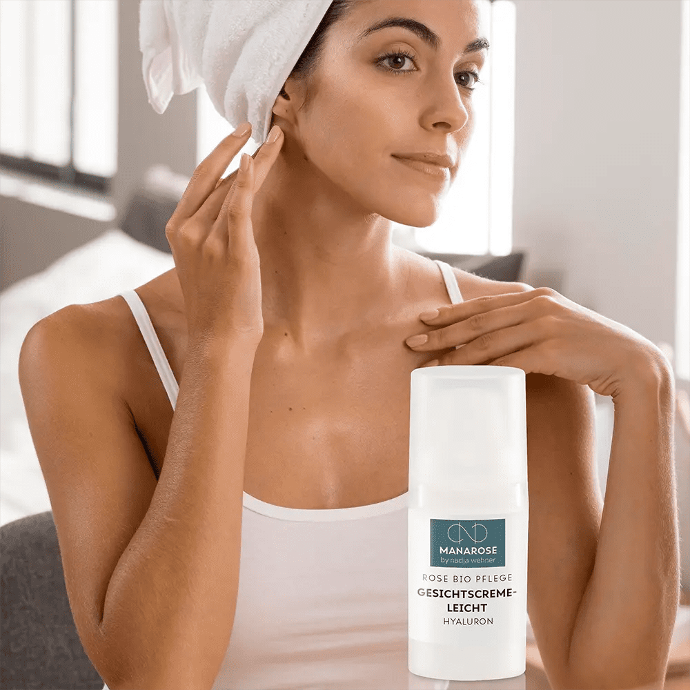 Eine Frau mit einem Handtuch auf dem Kopf übt Hautpflege und untersucht ihr Gesicht mit dem Set für deine Morgenroutine von Manarose Biokosmetik.