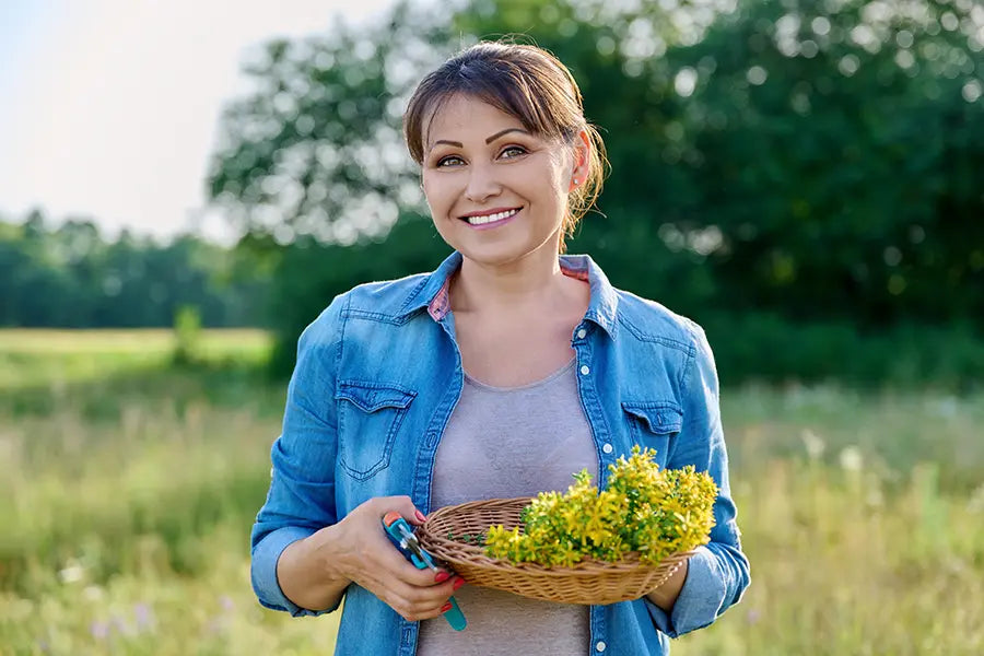 Junge Frau hält einen kleinen Korb mit gelben Blumen in der Hand