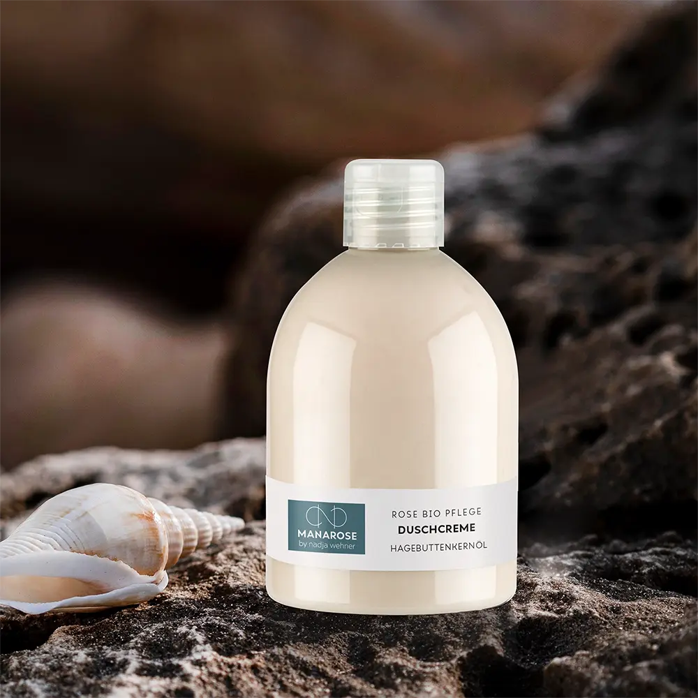 Eine Flasche Manarose Biokosmetik Duschcreme Hagebuttenkernöl Körperlotion sitzt auf einem Felsen.