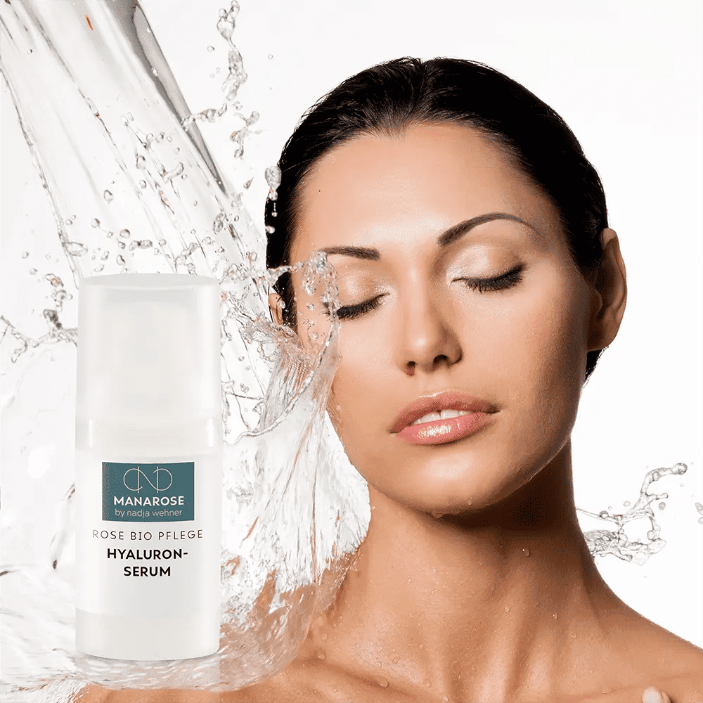 Das Gesicht einer Frau wird mit Hyaluron Serum Rose von Manarose Biokosmetik bespritzt, das ihre Haut mit Feuchtigkeit versorgt und der Hautalterung vorbeugt.