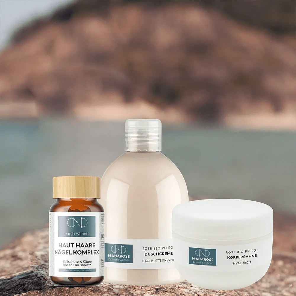 Eine Flasche Pflegeset von Manarose Biokosmetik – Perfect Legs natürliche Hautpflegeprodukte und eine Flasche Wasser auf einem Felsen.