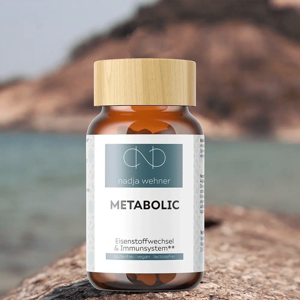 Eine Flasche Metabolic Care von Manarose Biokosmetik steht auf einem Felsen am Meer.