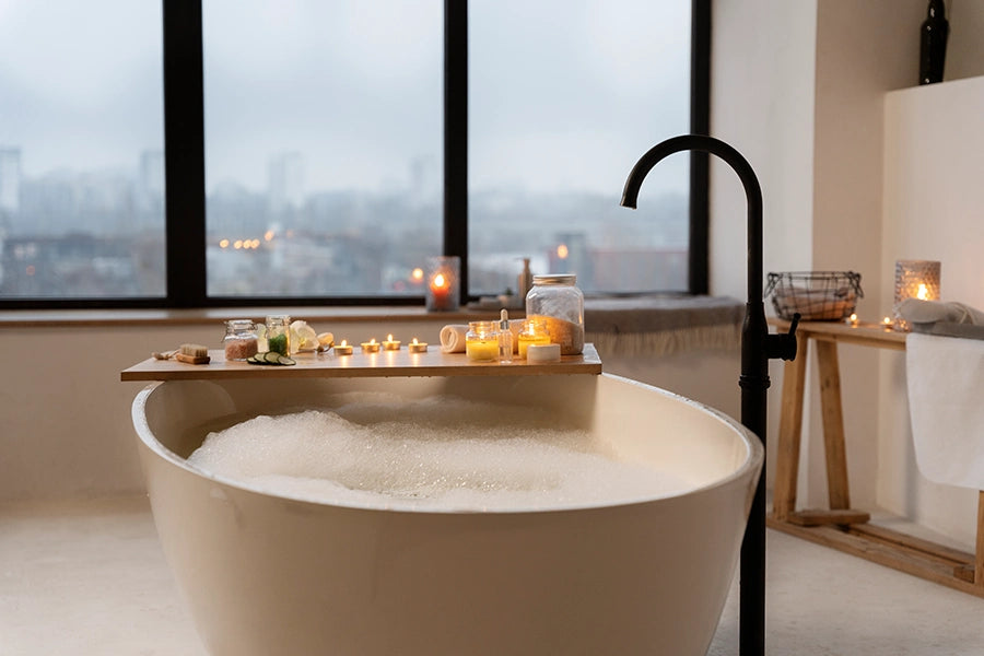 Bild zeigt eine Badewanne mit Schaum und rundherum Kerzen