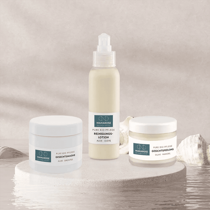 Ein Set von Manarose Biokosmetik-Hautpflegeprodukten, darunter das Gesichtsreinigungsset - Perfect Skin, auf einem Tisch mit Muscheln für eine gesunde und strahlende Haut.